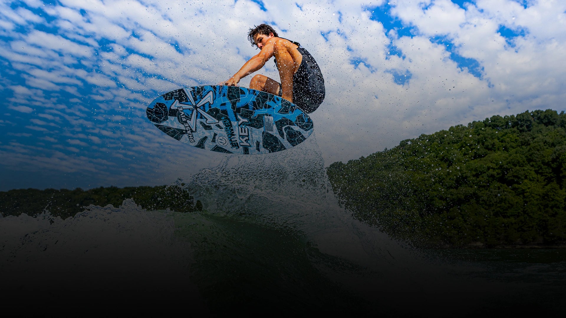 Phase Five rider airborne on a blue wakesurf board