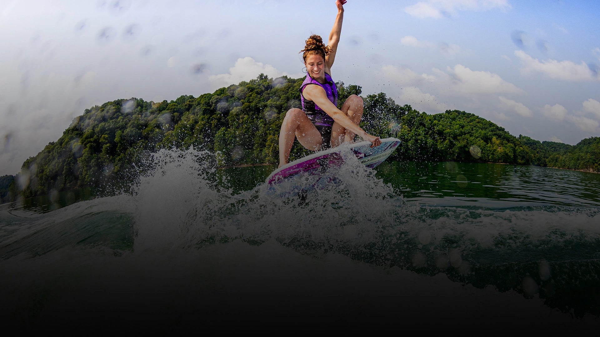 Phase Five rider in a purple vest surfing a white and purple board