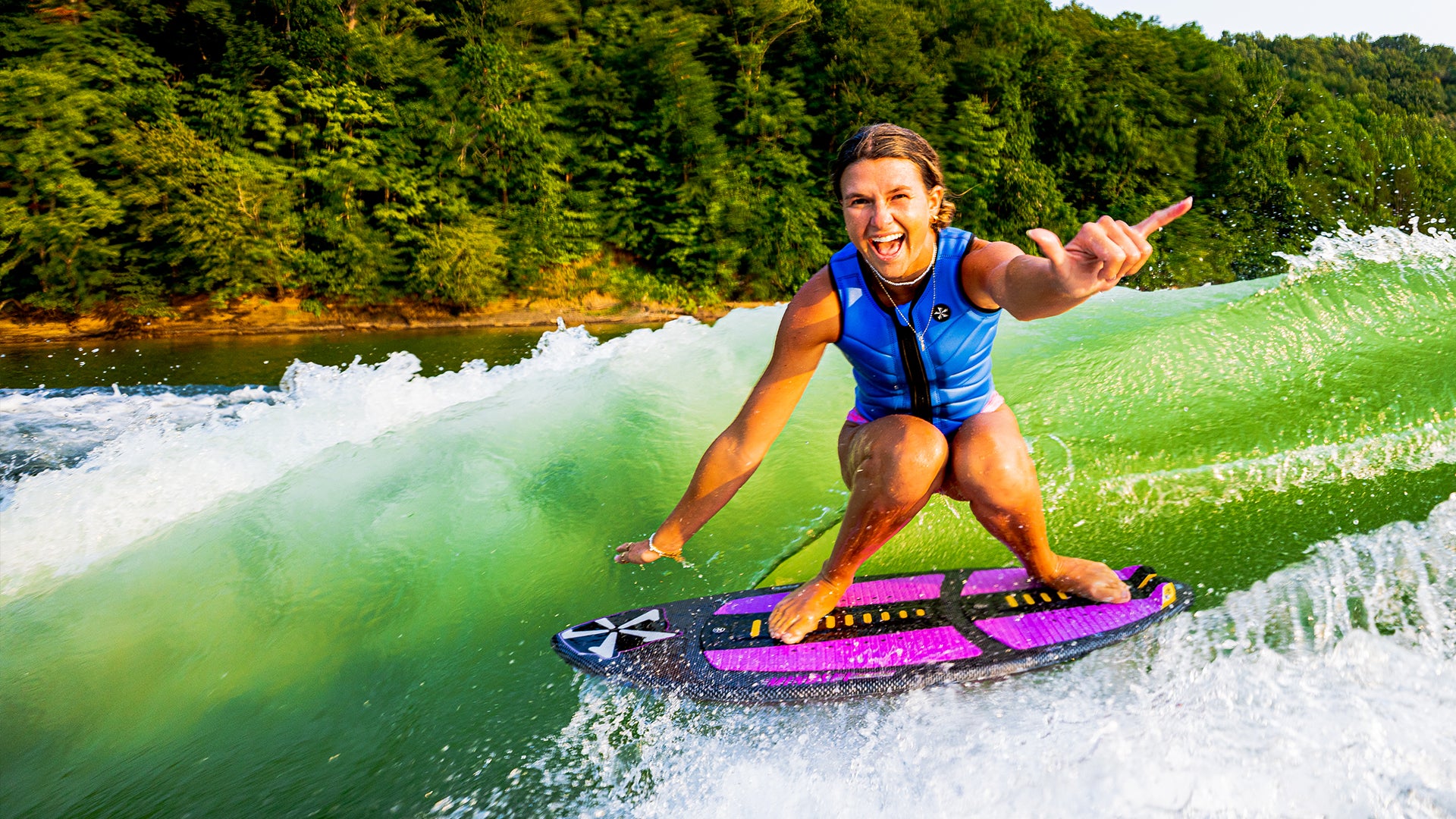 Phase Five rider surfing a purple board in a blue vest